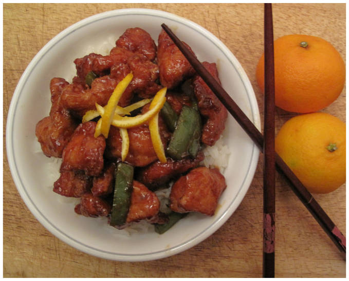 Sweet and sour orange chicken with green peppers, rice, and orange zest.