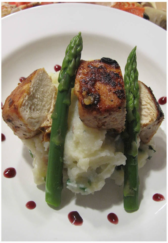 Orange-garlic chicken with crab mashed potatoes, blanched asparagus, and red wine reduction