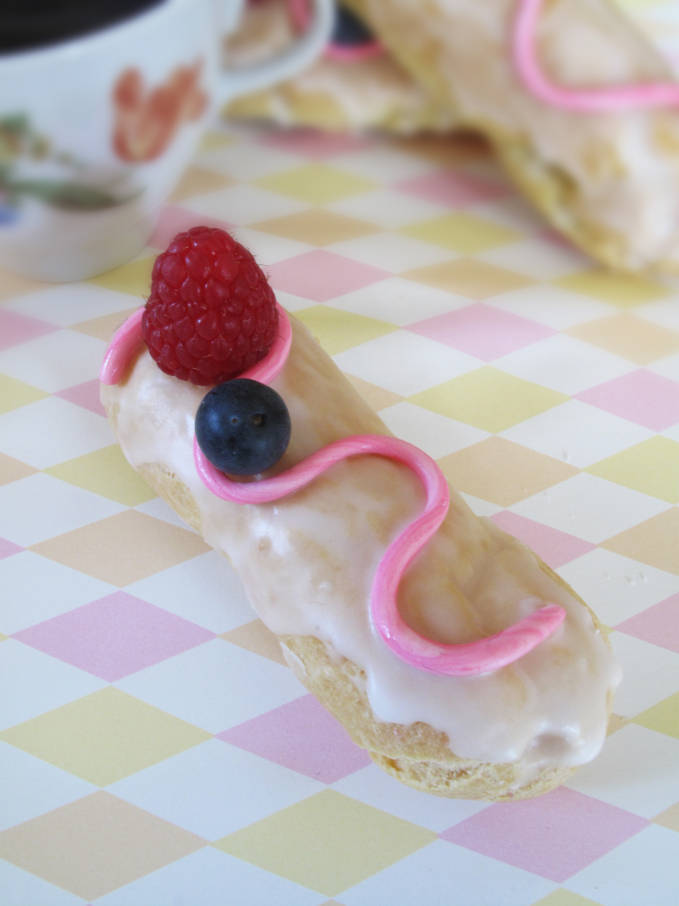 Raspberry éclair with pink fondant and fresh fruit