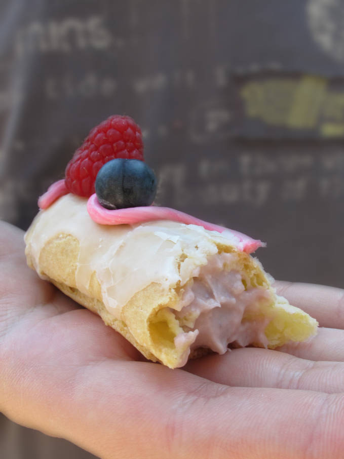 Raspberry éclair with raspberry pastry cream, icing, pink fondant, and fresh fruit