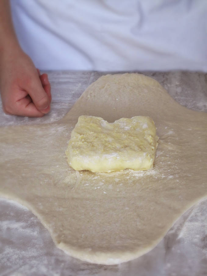 Beurrage (block of butter and flour) on the clover-leaf shaped detrempe (puff pastry or croissant dough)