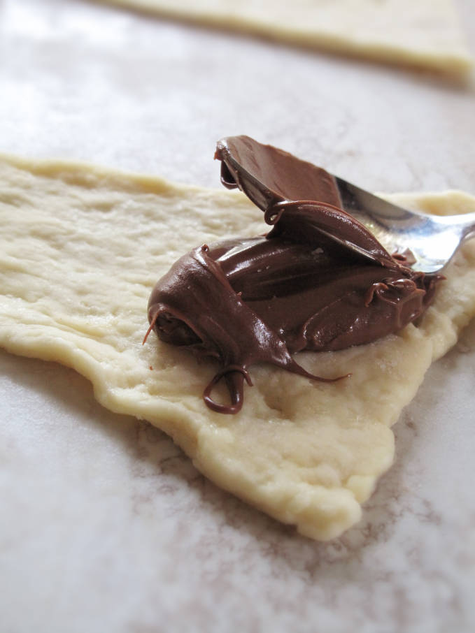 Filling croissants with Nutella chocolate hazelnut spread