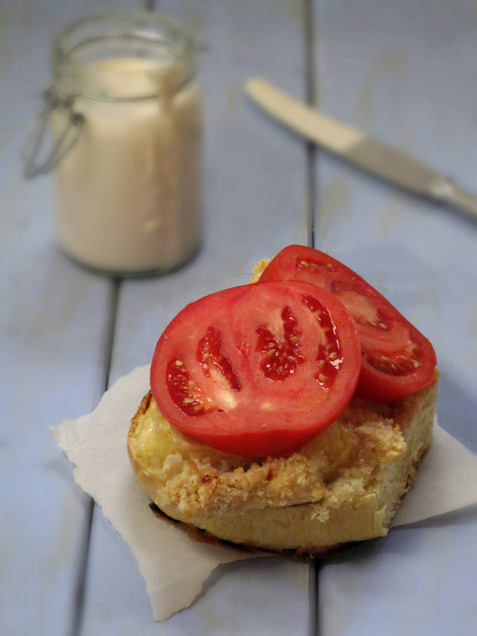 Challah hamburger bun with crispy chicken, melted cheese, and fresh sliced tomatoes