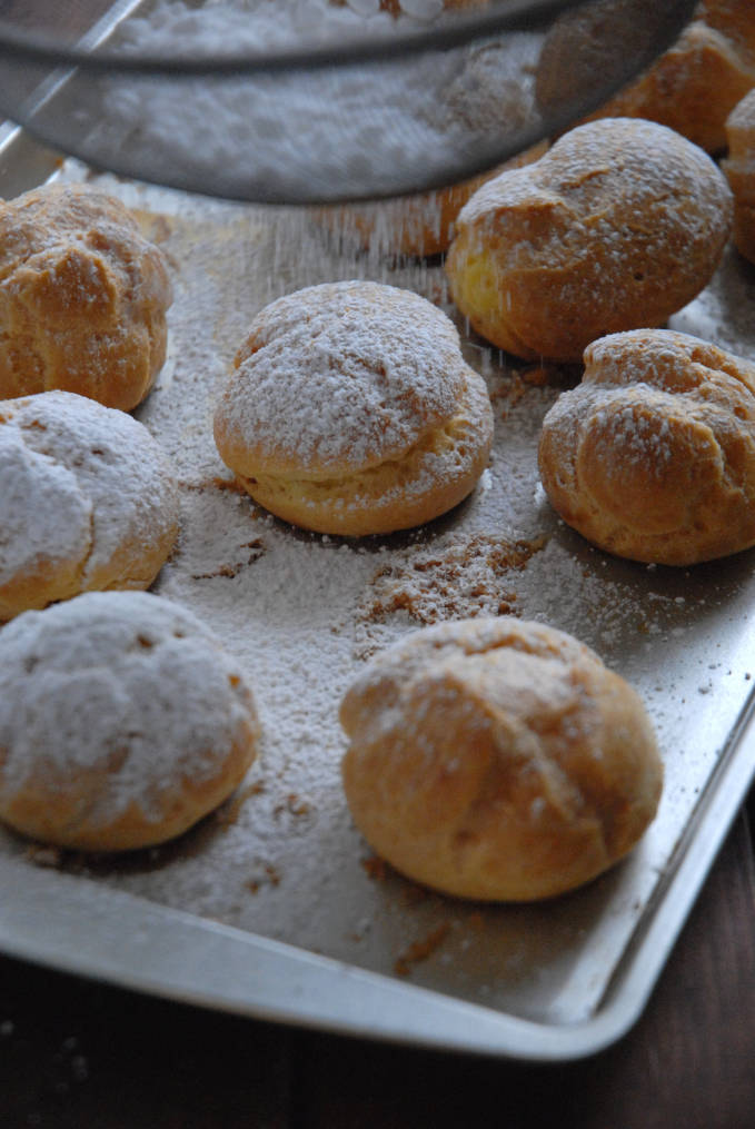 Cream puffs filled with vanilla pastry cream and dusted with icing sugar