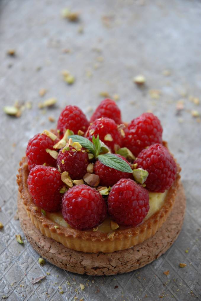 Raspberry and pistachio tartelette with vanilla pastry cream and a thin layer of white chocolate