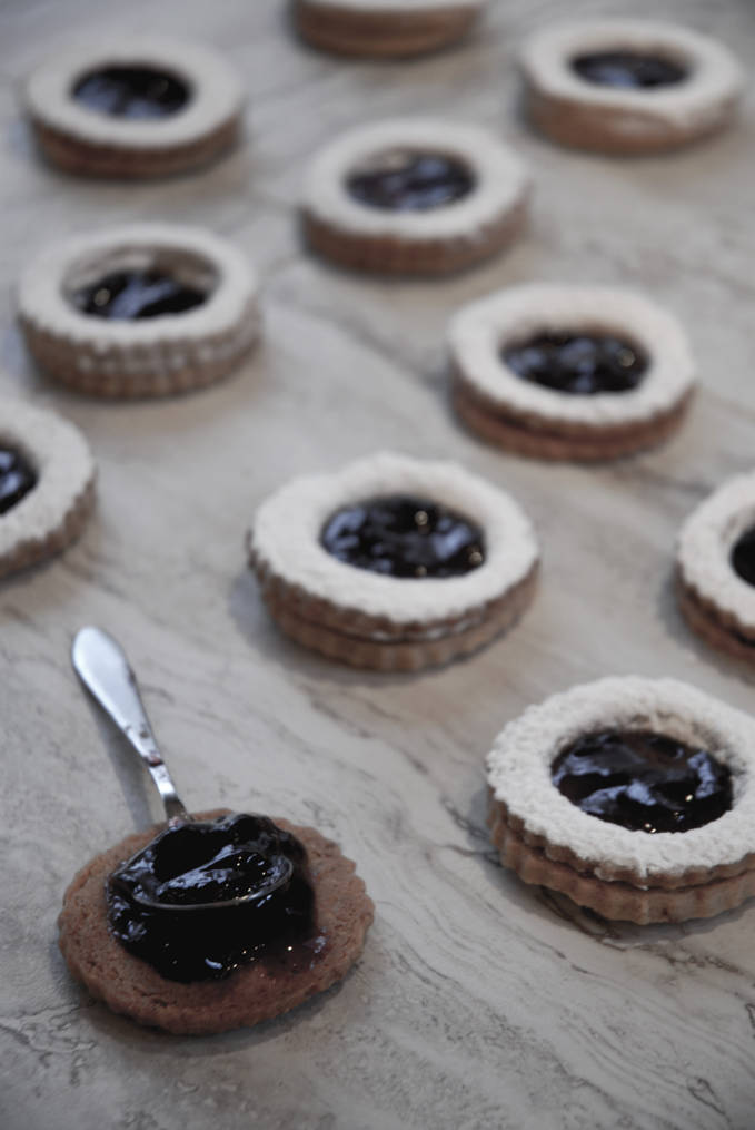 Pecan linzer cookies filled with raspberry jam and dusted with icing sugar. Click for the recipe!