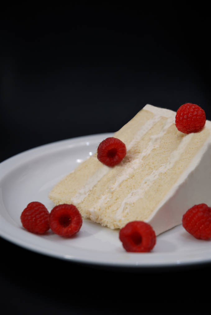 Fluffy vanilla cake frosted with whipped cream and topped with fresh raspberries. Click for the recipe!