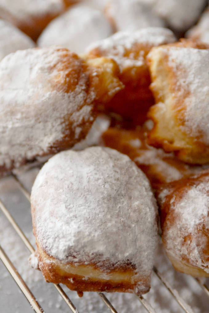 Buttermilk beignets dusted with icing sugar. Don't you just want a bite? They're super simple to make, and if you click to get the recipe you can eat 'em tonight!