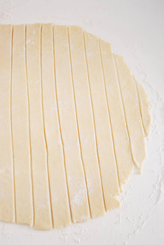 Cutting strips of dough is the first step of making a lattice pie crust--click to get a step-by-step photo tutorial on lattice pie crusts, so you can make them easily!