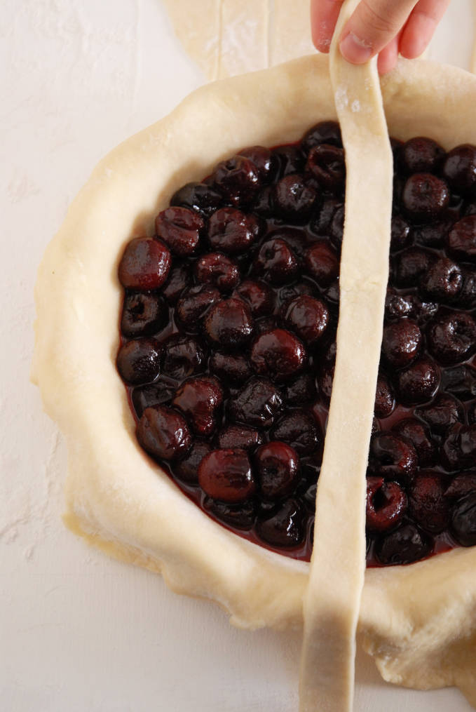 The first dough strip of a lattice pie--click to get a step-by-step photo tutorial on lattice pie crusts, so you can make them easily!