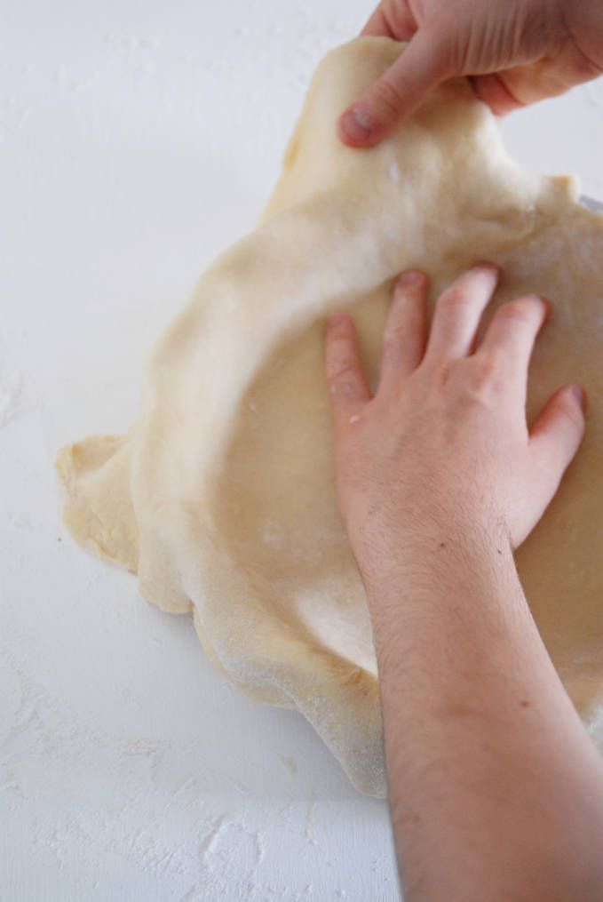 Pressing pie dough into the edges of the pan to ensure maximum filling space--click to get a step-by-step photo tutorial on lattice pie crusts, so you can make them easily!