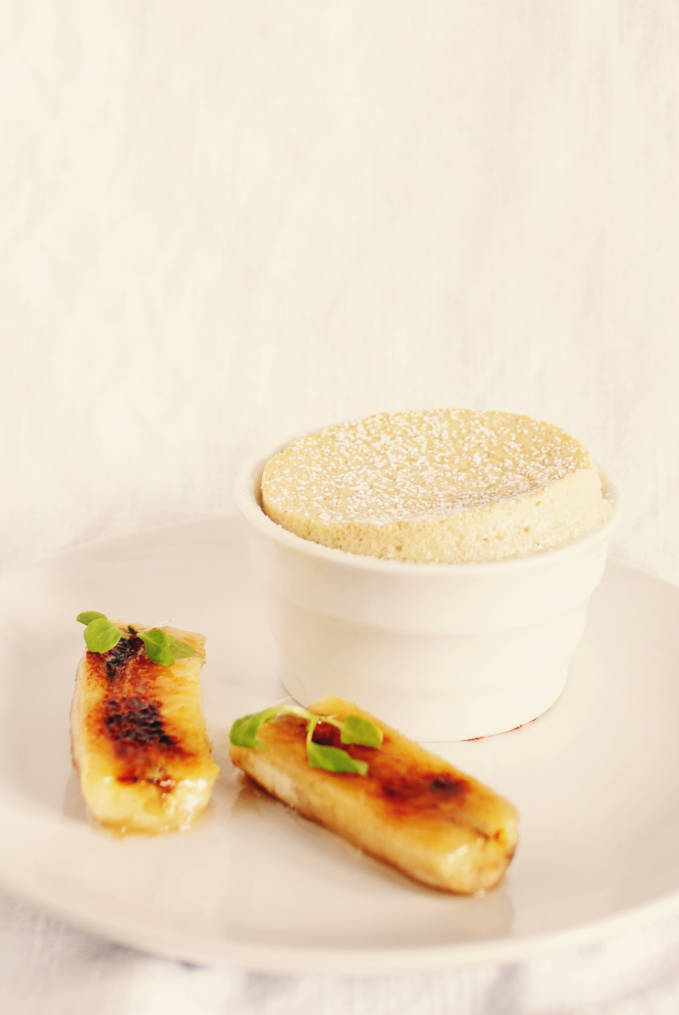 Craving something delicious? This recipe for EASY banana soufflé dusted with icing sugar and served with crunchy caramelized bananas is perfect! Click to get the recipe.