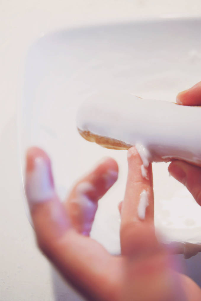 Breaking down the perfect éclair | Remove excess glaze from éclairs with your fingers for a perfect coating