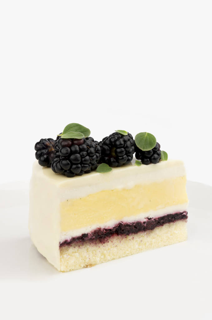 Blackberry, honey, and saffron entremet cake with sponge, honey simple syrup, blackberry coulis, honey mousse, saffron crème brûlée, and a white chocolate glaze.