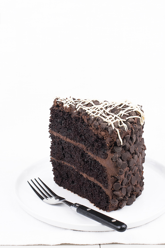 Chocolate cake with chocolate-cream cheese frosting rolled in chocolate chips and drizzled with white chocolate.