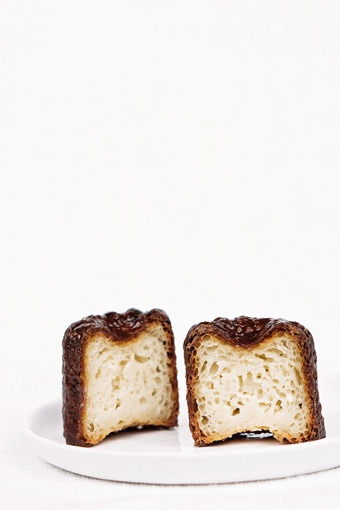 Traditional canelés (cannelés) with dark rum and Tahitian vanilla split in half to show custardy interior