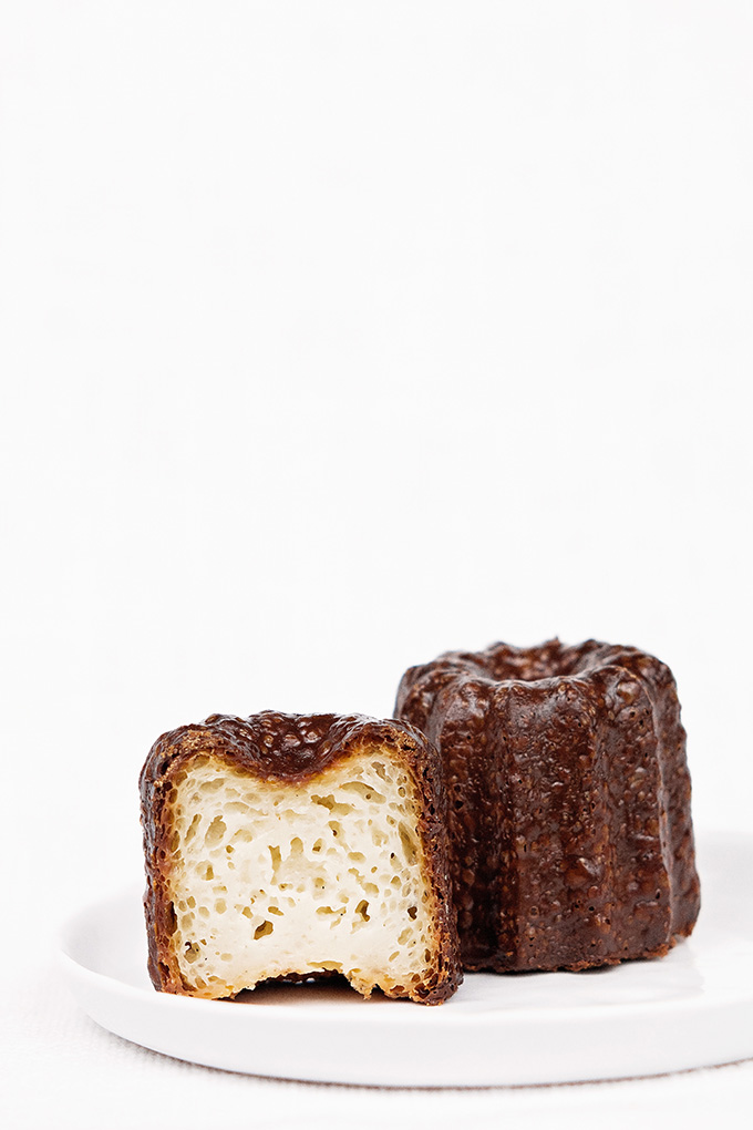 Traditional canelés (cannelés) with dark rum and Tahitian vanilla split in half to show custardy interior